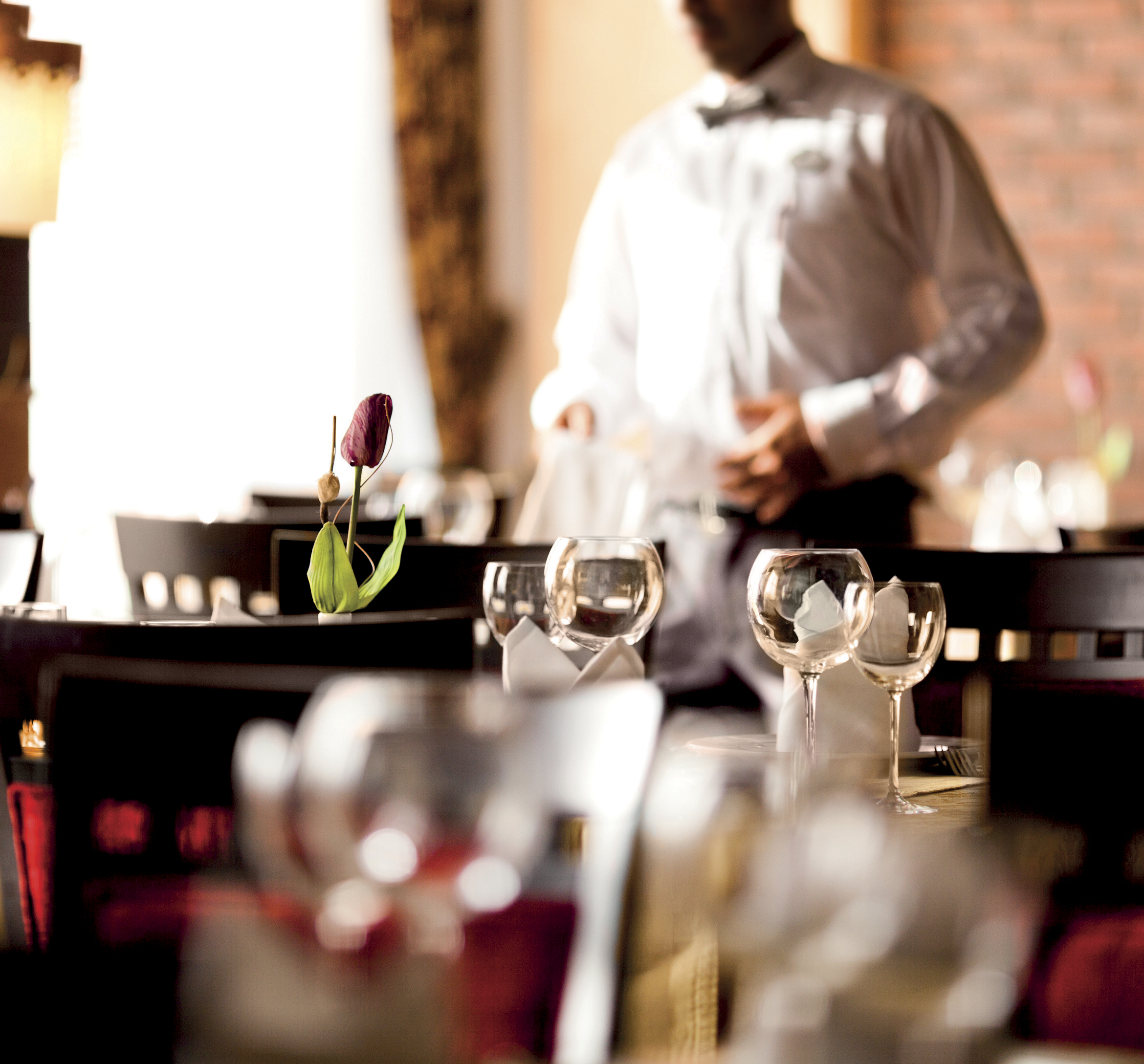 Waiter and Empty dining room of fancy restaurant